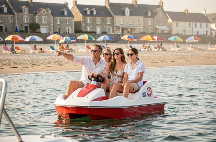 Famille en vacances sur un pédalo en Bretagne avec plage et promenade en arrière-plan